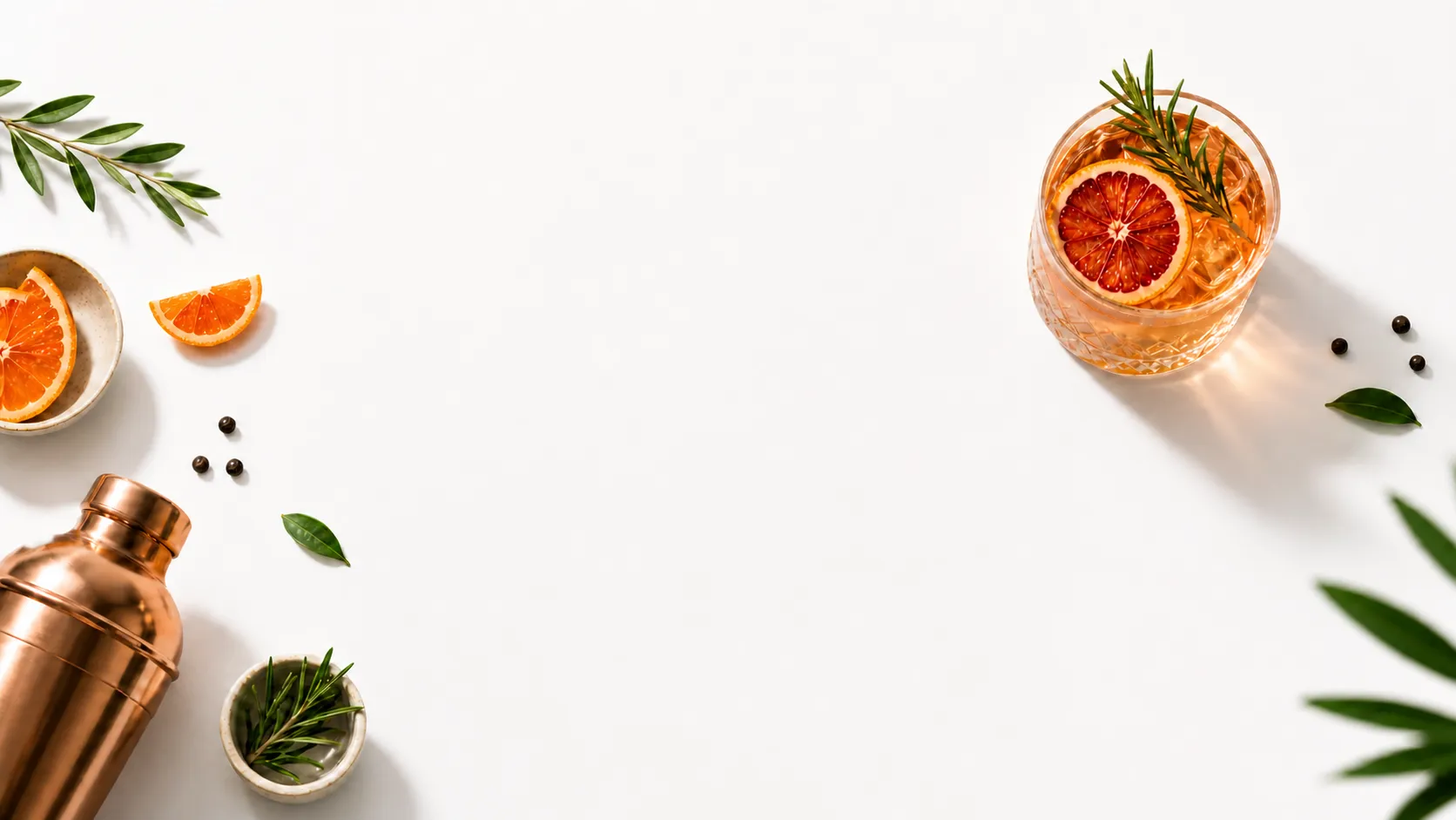 Curated cocktail flatlay with shaker, citrus and herbs